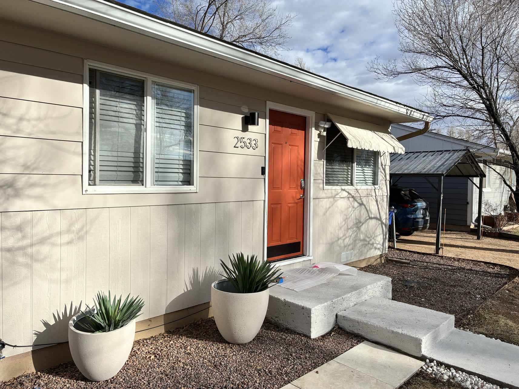 Colorado house after renovation with coral door and modern landscaping