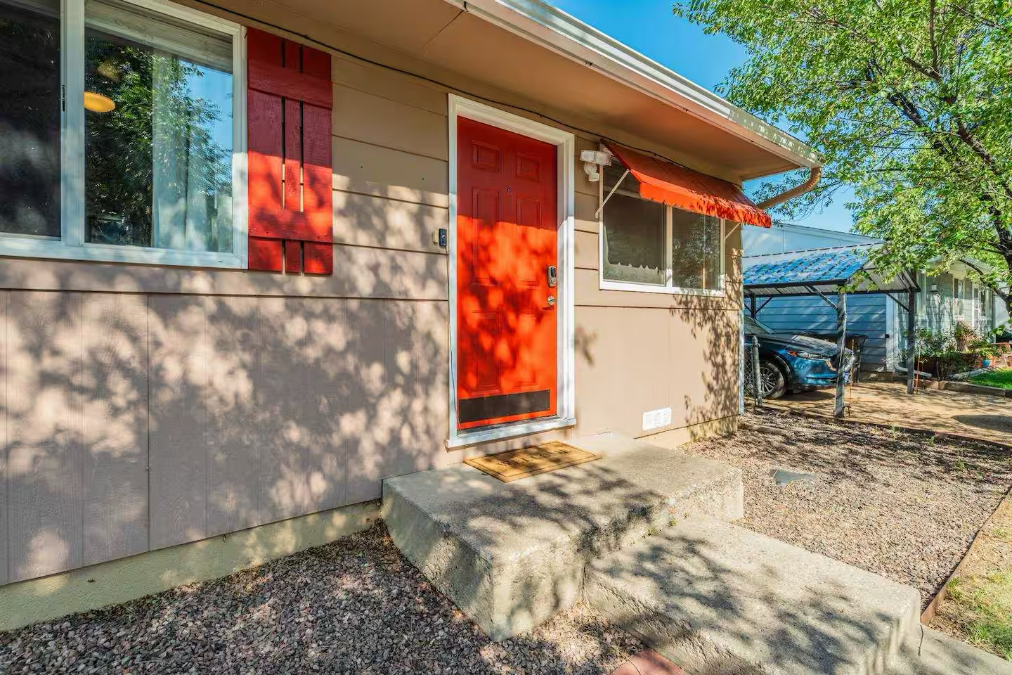 Colorado house before renovation with bright red door and shutters
